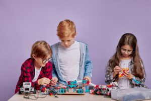 Technik Drei Kinder arbeiten an einem Technischen Aufbau aus Lego